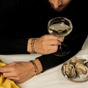 bracciale rigido in oro bianco con croce centrale di diamanti e diamanti neri