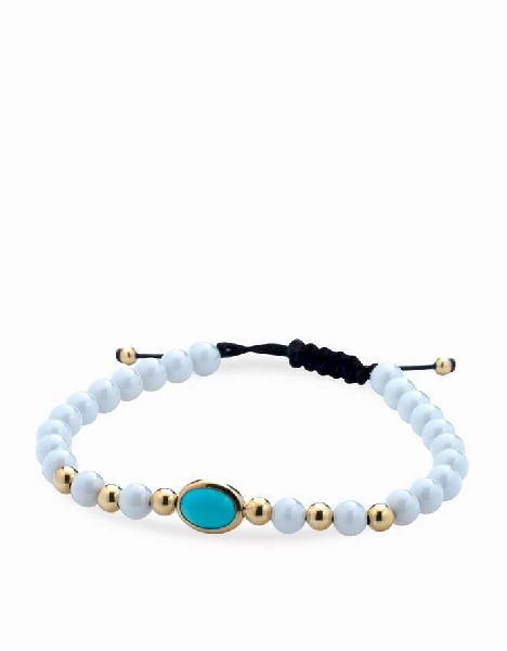 bracciale con palline bianche in ceramica e oro giallo e pietra centrale azzurra
